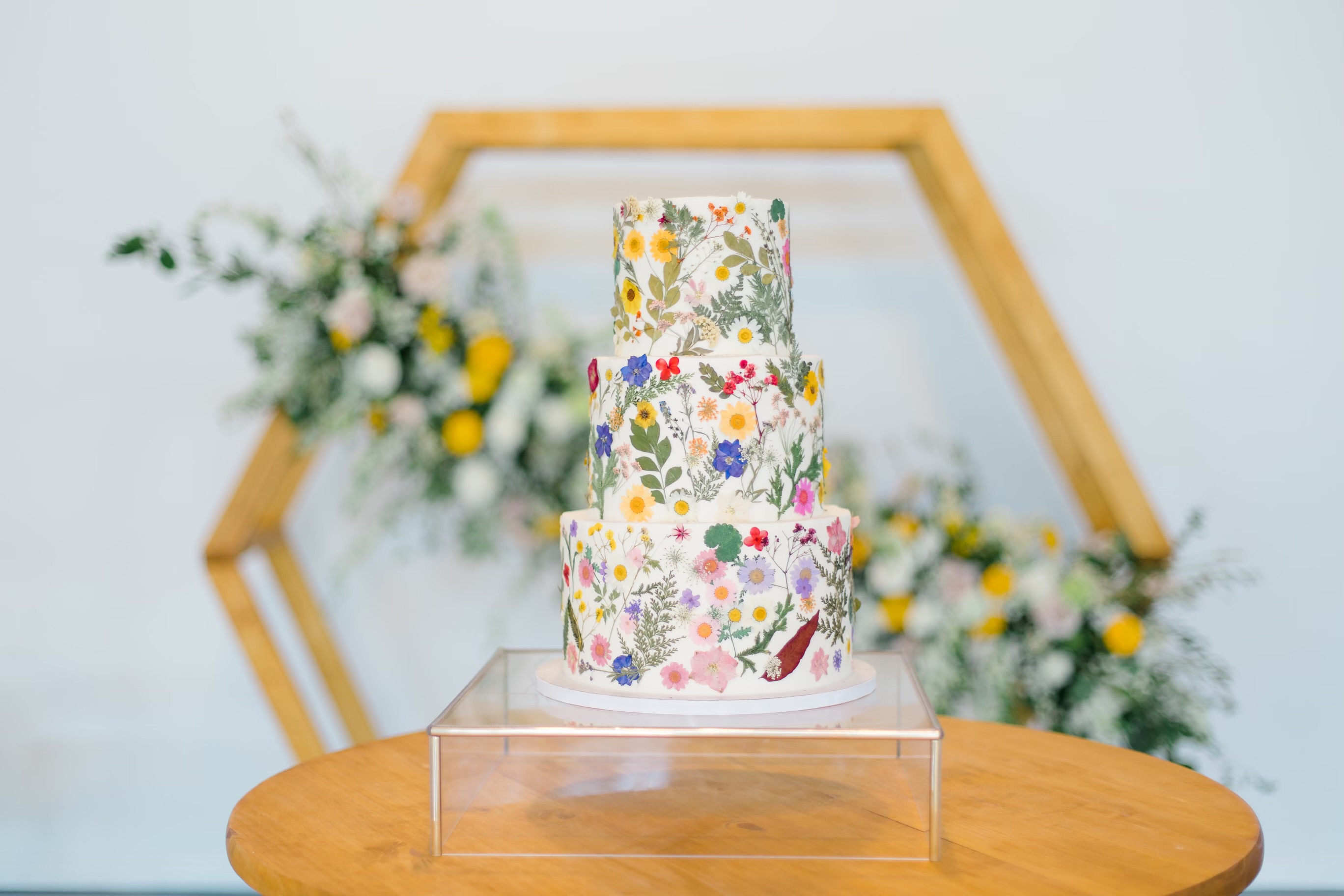 Wedding cake and flowers displayed on a wooden table