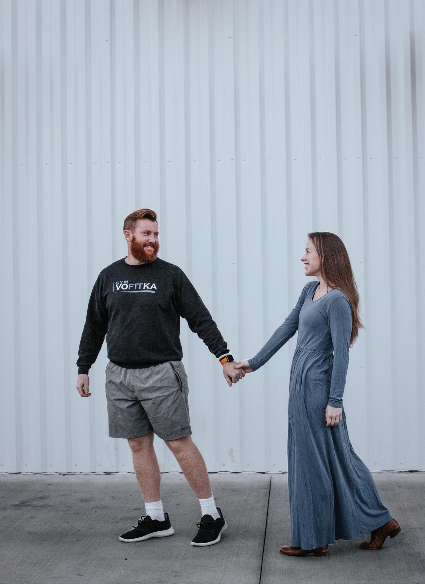 A couple holding hands outside the building