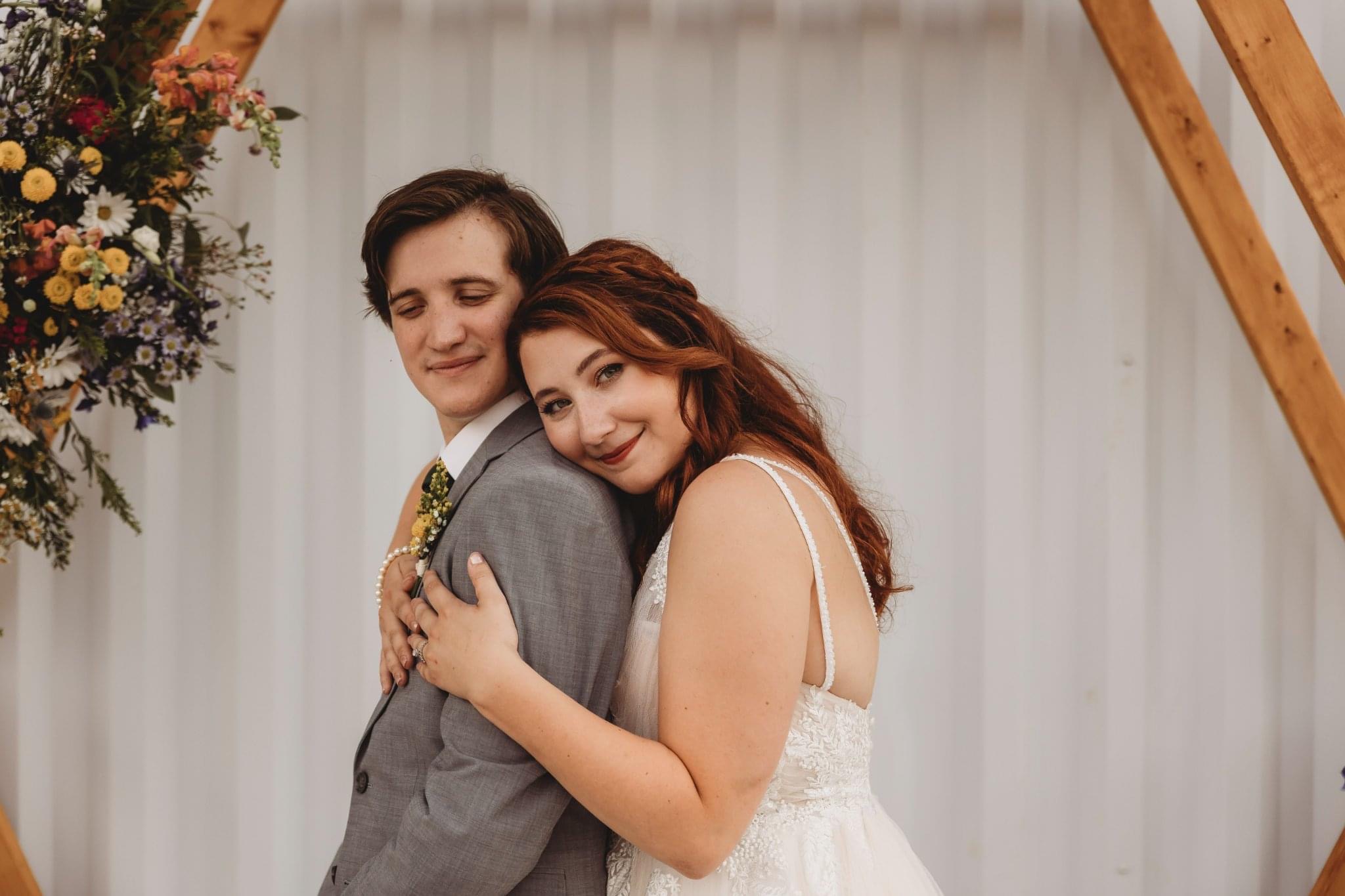 Bride and groom together beneath warm timber beams