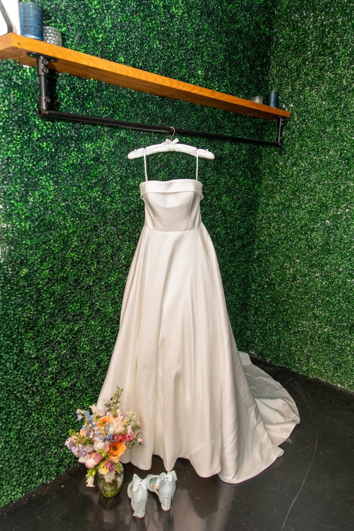 Wedding dress displayed in the bridal suite against the green feature wall
